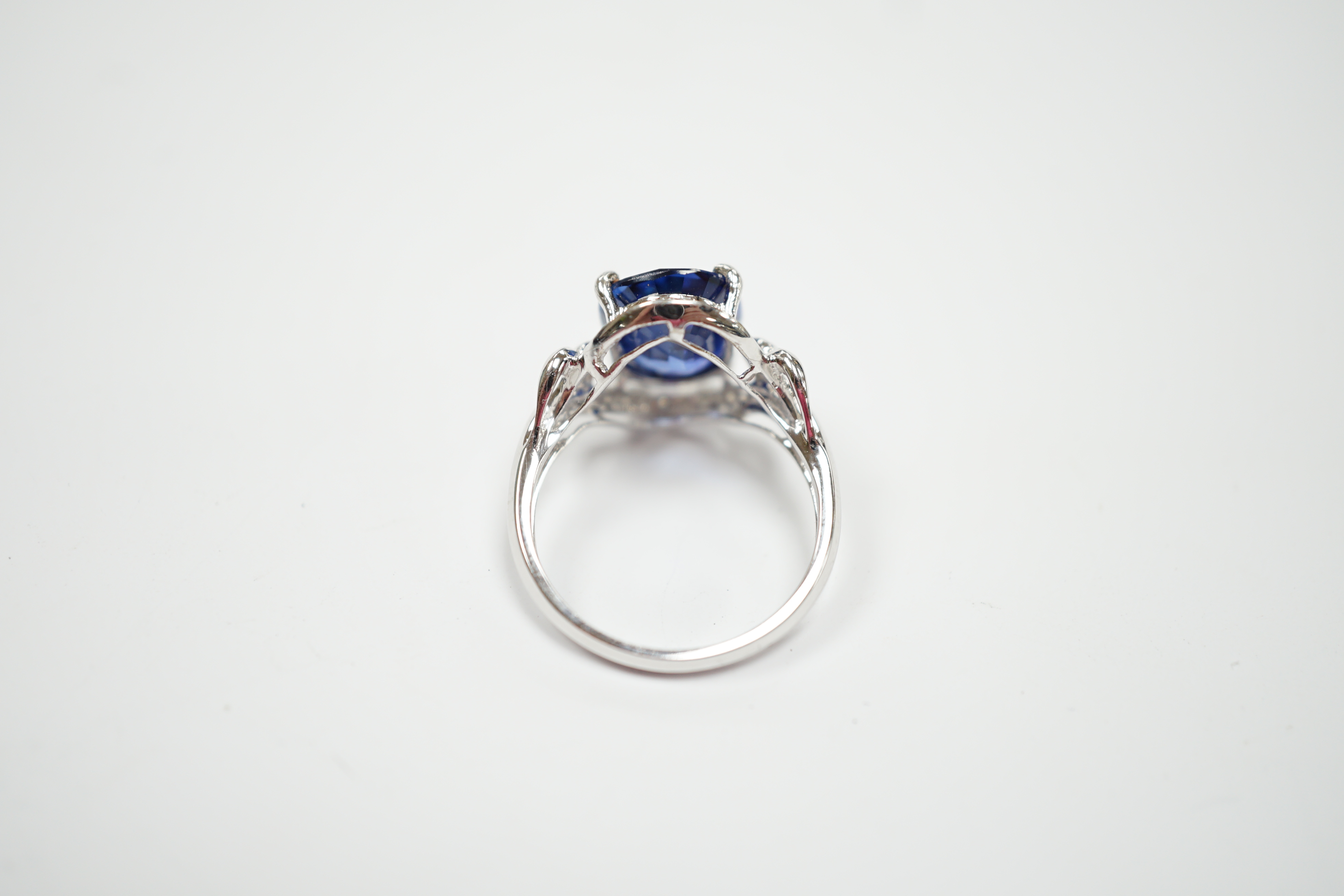 A modern 10k white metal, sapphire and diamond chip set oval cluster set dress ring, size M, gross weight 3.7 grams.